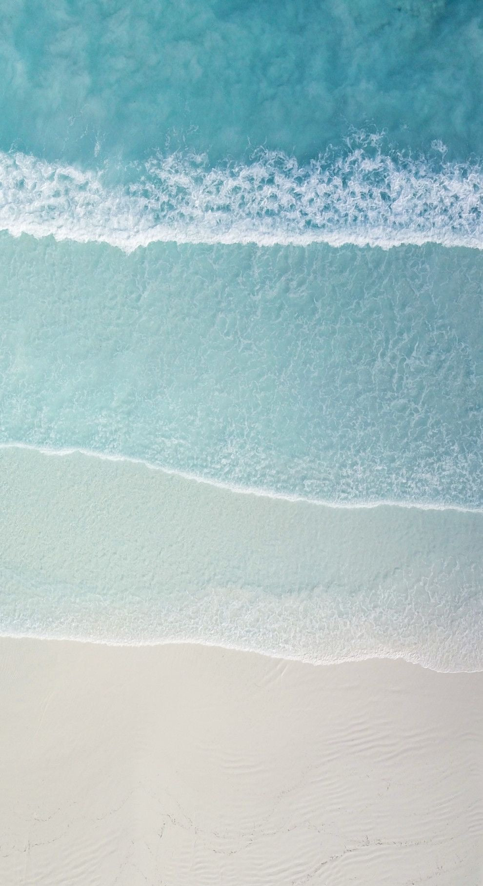 ocean waves crashing on the  sandy shore, the waves are in 4 tires. Shades of blue fade to sand in a clam colour gradient 